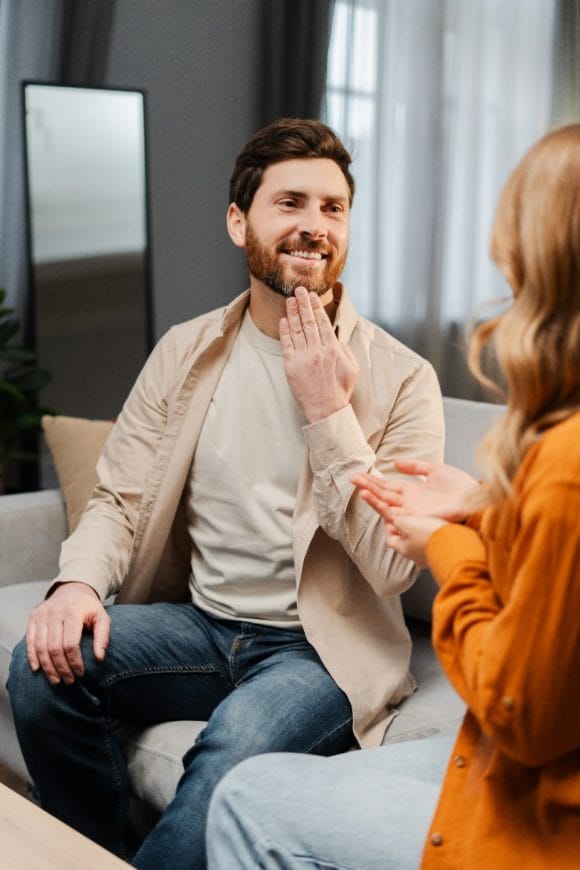 Middle-aged man having conversation with his female colleague using a sign language.