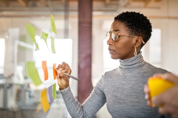 Woman writing on sticky notes