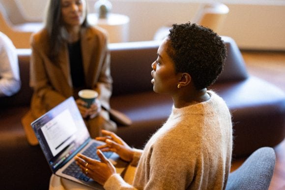 Woman talking to colleagues with a laptop