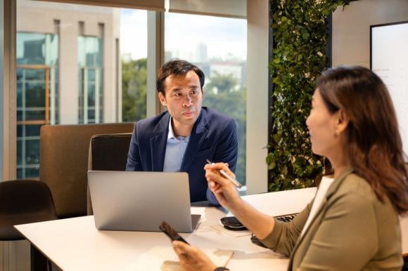 A man and a woman having a meeting with a laptop
