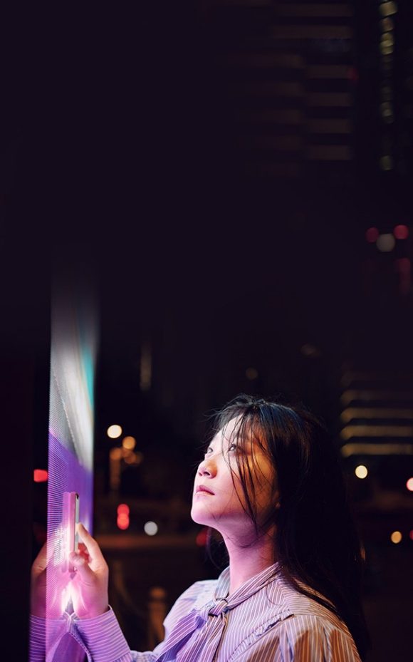 A young woman looking at a digital see through screen
