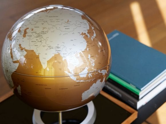 A globe and books on a coffee table