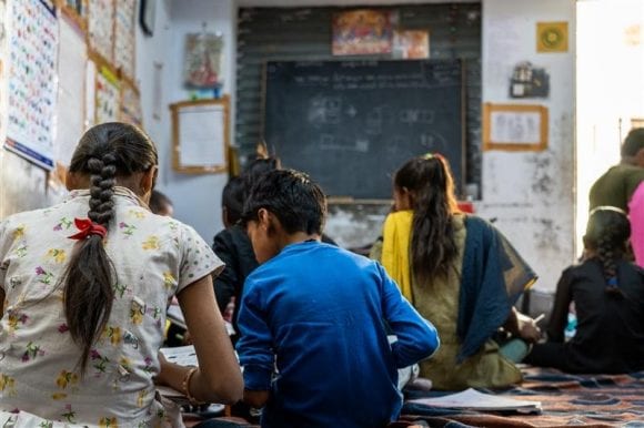 Children sit on the floor of a rural Indian classroom, engaged in learning, as part of the Educate Girls program