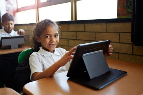 Young girl smiling using a tablet