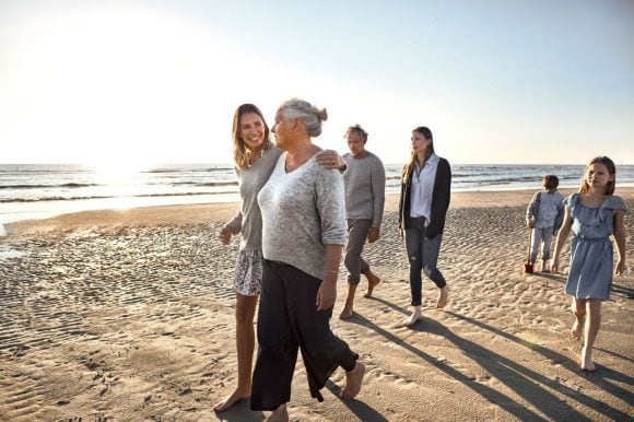 A group of people walking on a beach