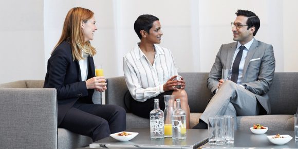 Two women entrepreneurs and one man entrepreneur discussing the long-term financial planning of their business on the couch