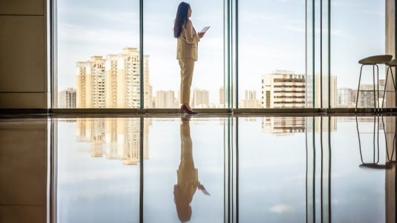 Businesswomen with tablet computer looking out of window