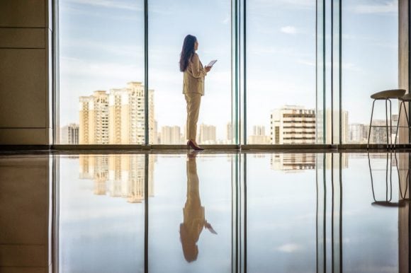 Businesswomen with tablet computer looking out of window