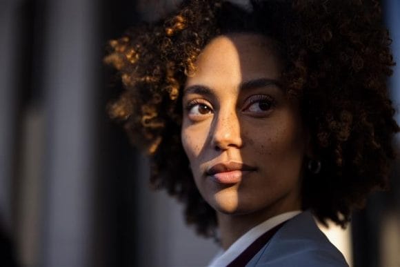 Curly-haired woman in partial sunlight