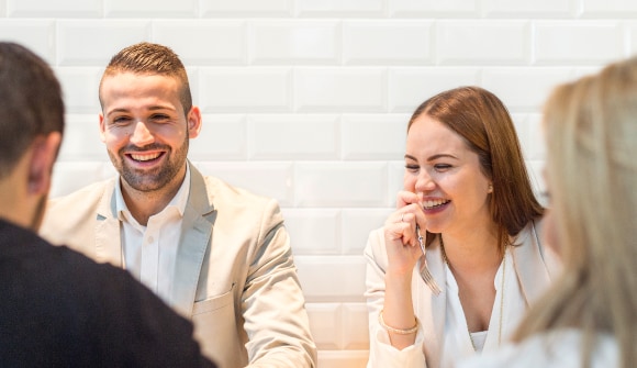 Details for Young people socializing and laughing at a table