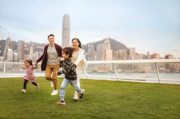 Family running in front of Hong Kong skyline