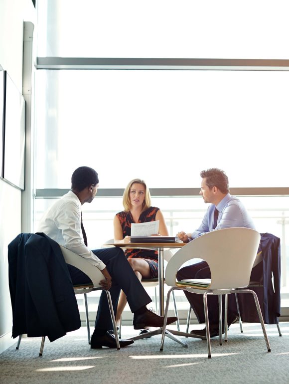 Two colleagues in meeting in office conference room.