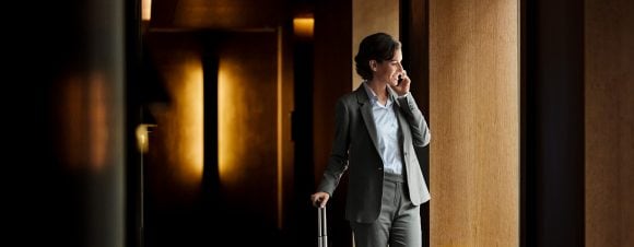 Businesswoman talking on phone in hotel corridor