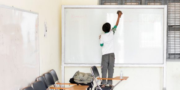 Student cleaning white board