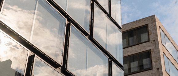 Close-up of two buildings, reflection of  cloudy sky in windows