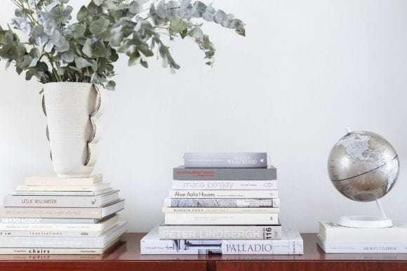 Globe with Americas displayed, next to a pile of books and a plant