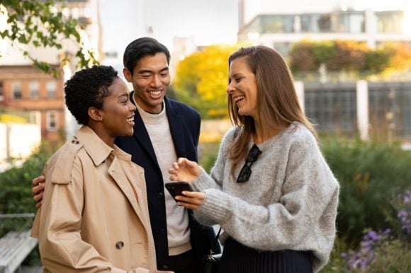 Young group laughing female and male phone focus
