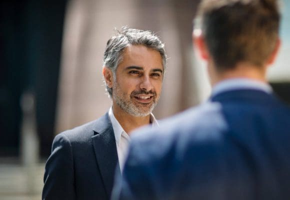 Two businessmen talking in street