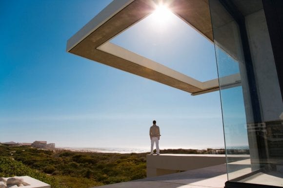 Man standing on an edge of a house looking at the sky