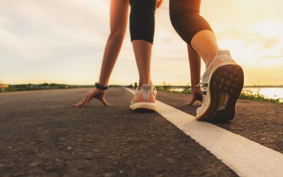 sport runner feet running on sunset lake closeup on shoe