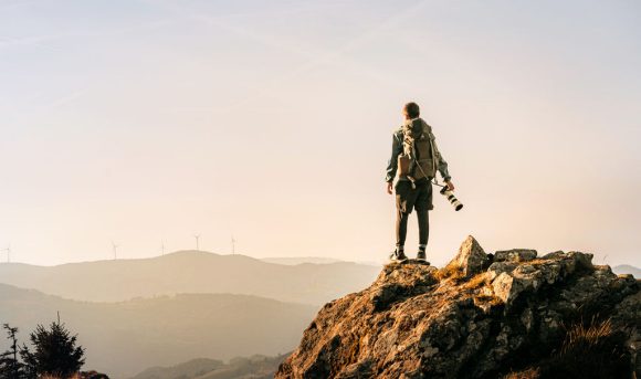 Hiker looking at wind power station in distance