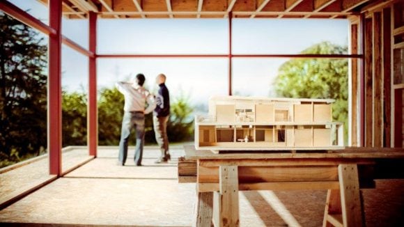 2 people inspecting the structure of a building