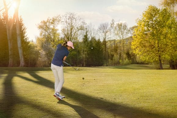 Female golf player at sunset