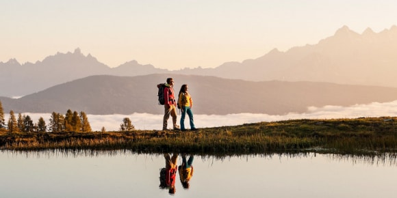 Two people looking over the horizon on a mountain 