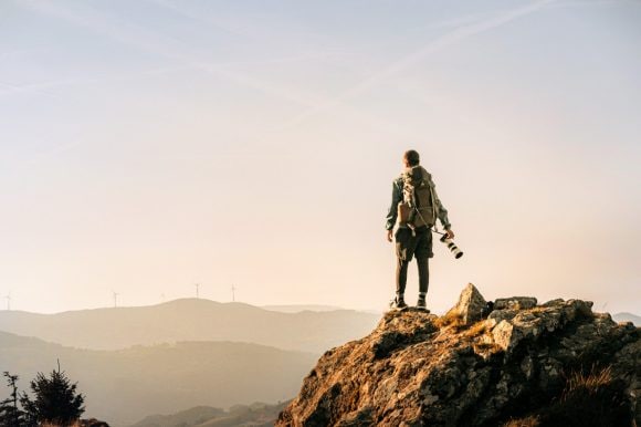 Hiker looking at wind power station in distance