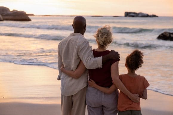 Grandparents with granddaughter on beach