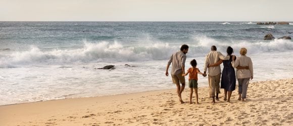 Three generation family walking on beach