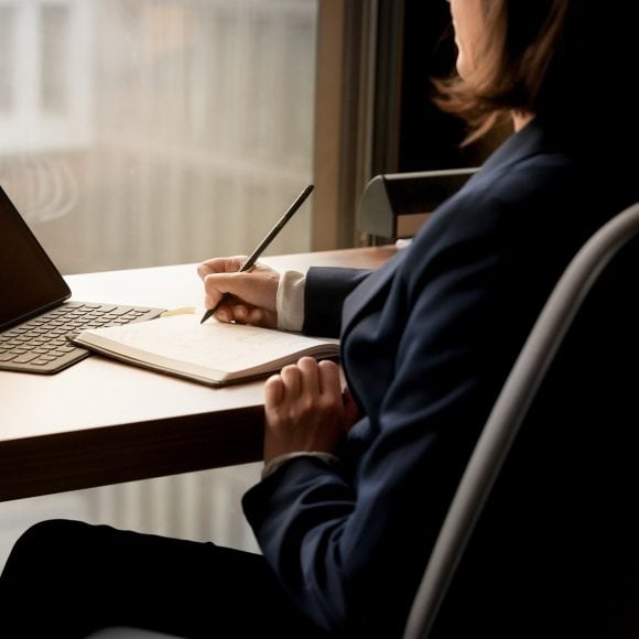 Woman writing and on laptop