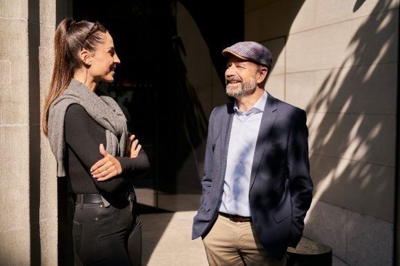 A couple standing and discussing in front of a building.