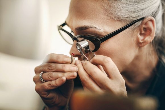 Jeweler looking through loupe at gemstone