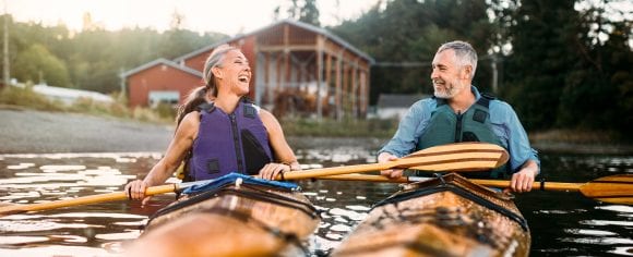 A middle-aged woman and man kayaking in a rustic setting