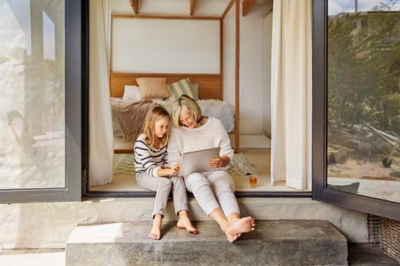 Grandmother showing granddaughter tablet  