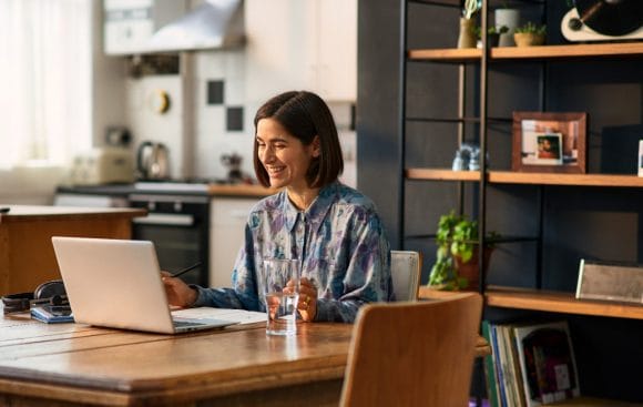 Smiling woman viewing laptop during virtual call