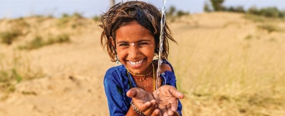 Indian little girl drinking fresh water, desert village