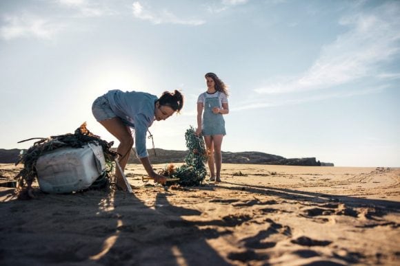 two women cleaningup beach