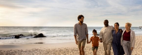 Three generation family walking on beach