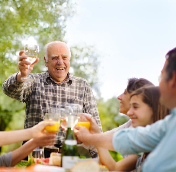 Grandfather toasting at family meal