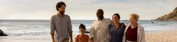 Three generation family walking on beach