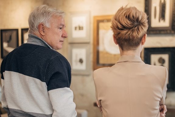 Couple looking at paintings and talking about business