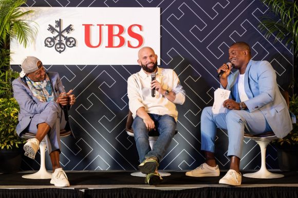 Kevin Liles, Steve Rifkind and Wale Ogunleye on stage speaking during their panel conversation