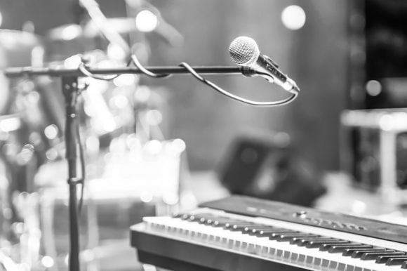 Microphone for a singer is standing next to a keyboard.