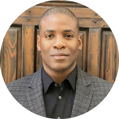 Portrait of Wale Ogunleye in front of wooden paneling