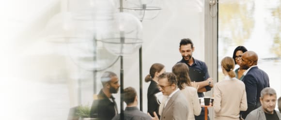 Group of people of diverse genders and ethnicities mingling at an intimate gathering and event.