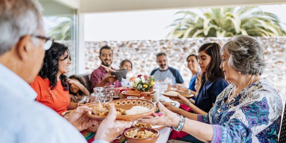 A young Asian woman sips a coffee in the back seat of a car, taking in the view at sunrise or sunset