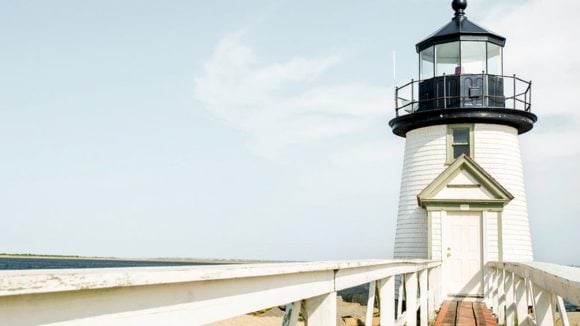 Dramatic shot of a lighthouse against a backdrop of an expansive beach